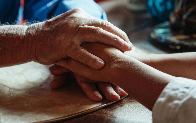 Hands gently holding in a moment of faith-based spiritual healing and compassionate community support.